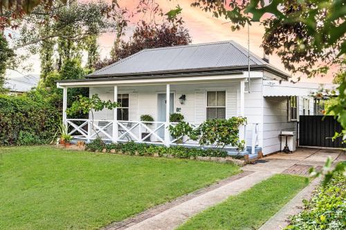 a white house with a porch and a yard at The Little White Cottage - Country Elegance Near CBD in Mudgee