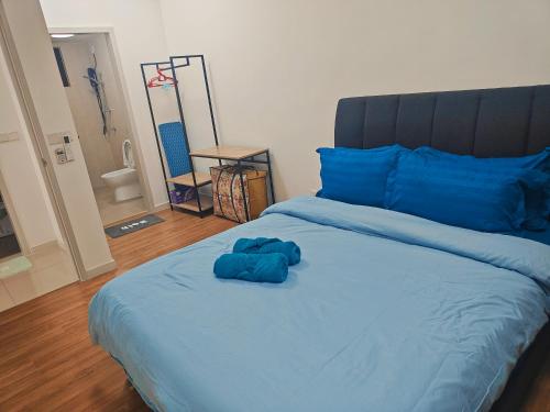 a large bed with blue sheets and blue pillows at Cozy Southville Bangi Free parking Wifi Netflix in Bangi