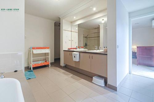 une grande salle de bain avec un lavabo et un miroir dans l'établissement Balwyn Luxury 5BR Mansion with Cinema & BBQ, à Melbourne