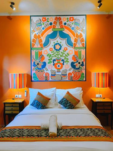a bedroom with a large bed with a painting on the wall at Villa Amador by Suasana Villa in Jarakan