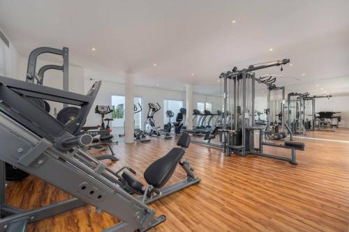 a gym with a row of treadmills and machines at NEW Condo at El Medano in Cabo San Lucas