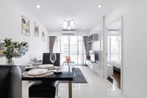 a living room with a table and a dining room at Shine Sukhumvit 43 Aparthotel Phrompong in Bangkok