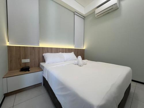 a bedroom with a white bed with a teddy bear on it at Cozy Urban Suites Georgetown View in Jelutong