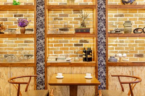 a table and chairs in a room with a brick wall at Breeze Alley Inn--English reception-Tourism planing-Ticket reservation in Zhangjiajie