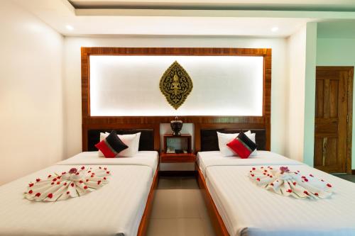 two beds in a room with white and red pillows at Peak Elite Boutique in Siem Reap