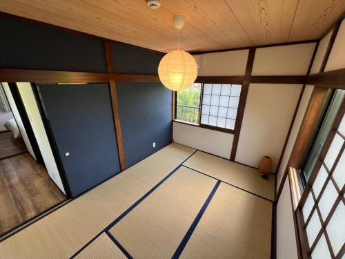 an empty room with blue walls and a chandelier at Kukuna外房 in Mobara