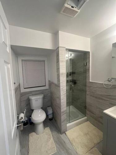 a bathroom with a toilet and a glass shower at Charming Unit in Yonkers Close to NYC in Yonkers