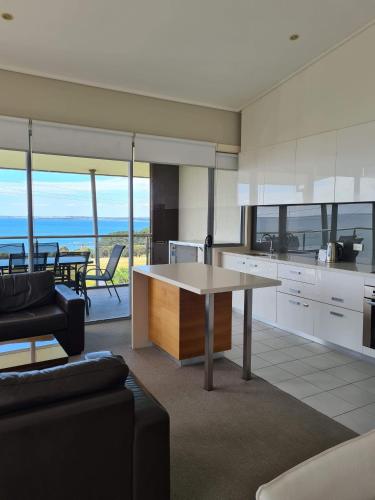 a kitchen and living room with a table and a couch at Silverwater Resort Phillip Island in San Remo