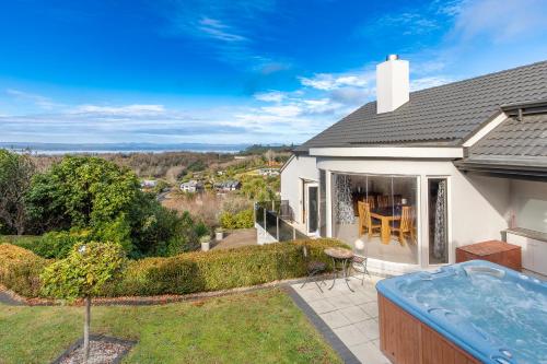 a home with a swimming pool and a house at Acacia Waters - Lake Taupo in Taupo