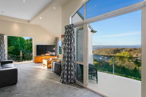an open living room with a large window and a tv at Acacia Waters - Lake Taupo in Taupo