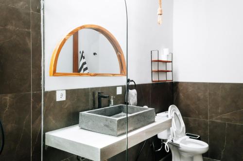 een badkamer met een wastafel en een toilet bij Casa Nebula Villa in Kerobokan