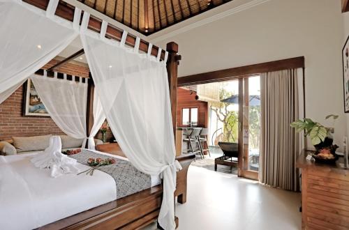 a bedroom with a bed with a canopy at HomeSix Bali in Uluwatu