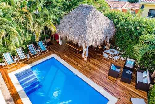 an overhead view of a pool with chairs and a straw umbrella at Villa Nautilus in Tamarindo
