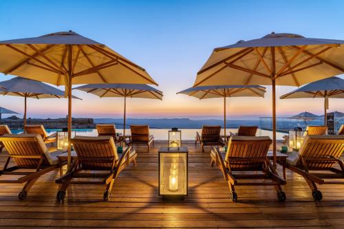 a group of chairs and umbrellas on a deck at Beresheet by Isrotel Exclusive in Mitzpe Ramon