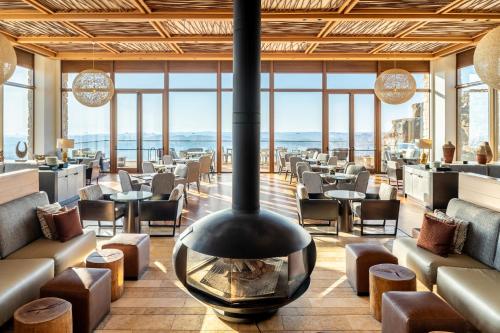 a restaurant with a fireplace in the middle of a room at Beresheet by Isrotel Exclusive in Mitzpe Ramon