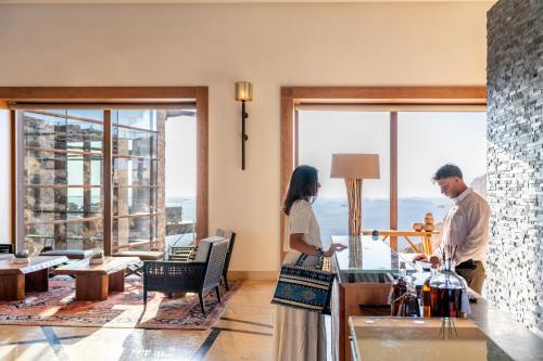 a man and woman standing in a kitchen with a counter at Beresheet by Isrotel Exclusive in Mitzpe Ramon