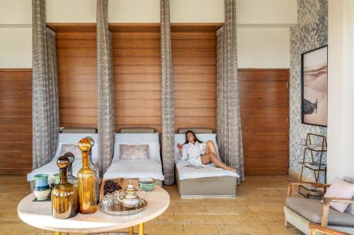 a woman sitting on a bed in a room at Beresheet by Isrotel Exclusive in Mitzpe Ramon