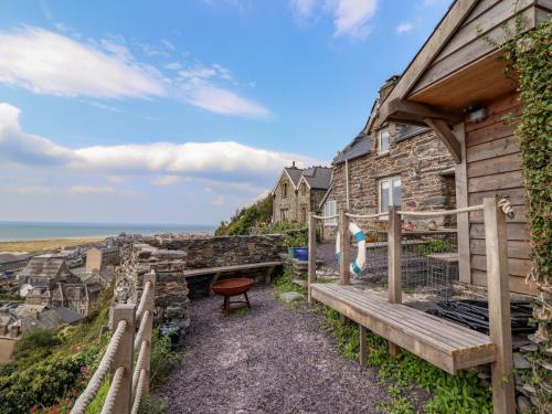 a stone house with a deck and a view of the ocean at Pengarreg in Barmouth
