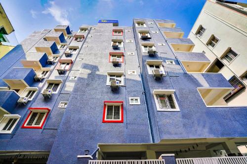 a tall blue building with red windows at FabExpress Grand Aarvi Prime - Nr GSM Mall, Madeenaguda in Lingampalli