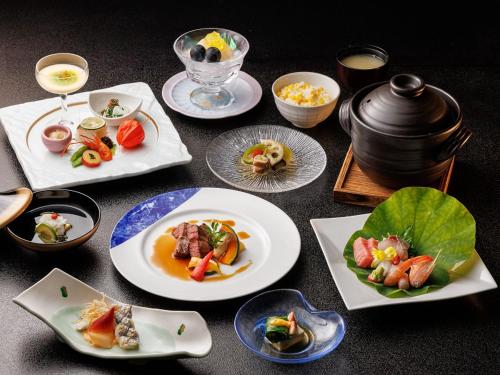 a table with plates of food and a pot at Chousenkaku Kameya in Shimo-suwa