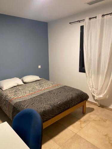 une chambre avec un lit et un mur bleu dans l'établissement Villa prestige en Provence, à Valréas