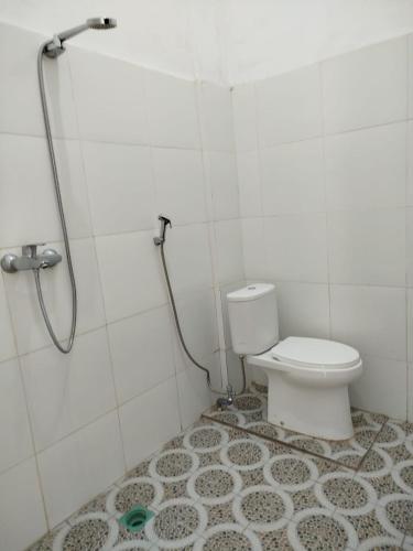 a bathroom with a toilet and a shower at Ilham Homestay in Kuta Lombok