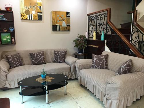 a living room with two couches and a table at Eagle Ridge Family Vacation House in General Trias