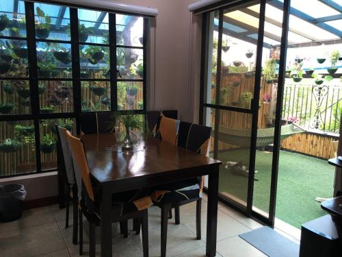 a dining room with a table and chairs and a patio at Eagle Ridge Family Vacation House in General Trias