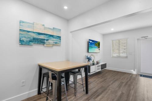 a dining room with a table and some paintings at Villa Mia Cozy Home in the heart of Miami in Miami