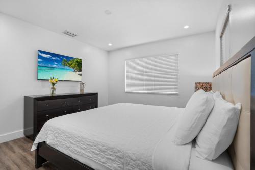 a white bedroom with a bed and a window at Villa Mia Cozy Home in the heart of Miami in Miami