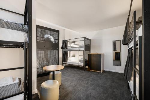 シドニーにあるYHA Sydney Centralの二段ベッド2台、テーブルが備わるドミトリールームです。
