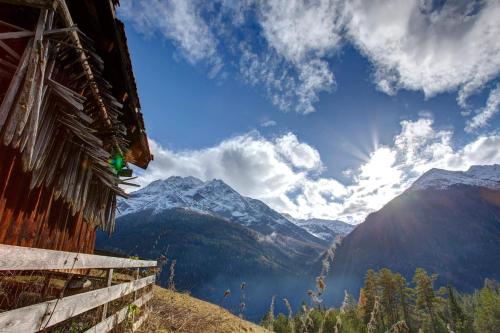 a view of a mountain range with the sun in the sky at Stöcklhof in Pettneu am Arlberg