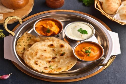 a plate of food with hummus and some dipping sauces at FabExpress Grand Aarvi Prime - Nr GSM Mall, Madeenaguda in Lingampalli