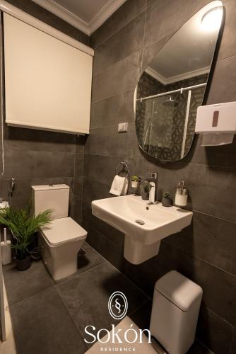 a bathroom with a sink and a toilet and a mirror at Sokón Residence - Cairo-New Cairo-Madinaty B7 in New cairo