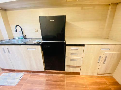a kitchen with a black refrigerator and a sink at Villa Imperial Diamond in Cibadak