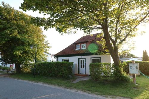 a small white house with a brown roof at Ferienwohnung bei Antje Timm in Hiddensee