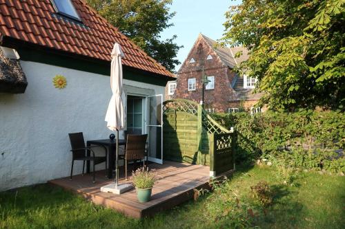 a wooden deck with a table and an umbrella at Ferienwohnung bei Antje Timm in Hiddensee
