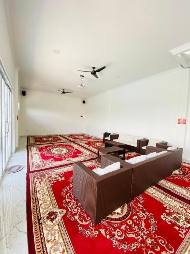 a living room with a red rug and chairs on the floor at Villa Imperial Diamond in Cibadak