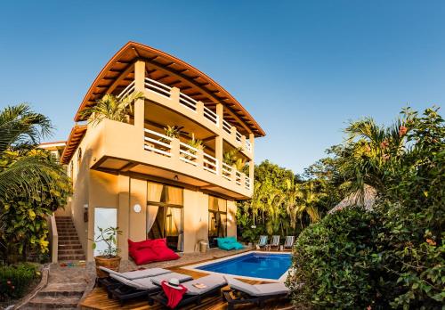 a house with a swimming pool next to a resort at Villa Nautilus in Tamarindo