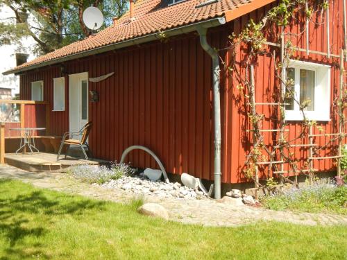 a red house with a table and a chair next to it at Schreinerhaus in Vitte
