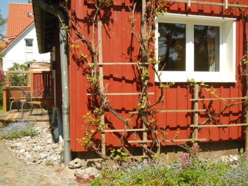 a red house with a window on the side of it at Schreinerhaus in Vitte
