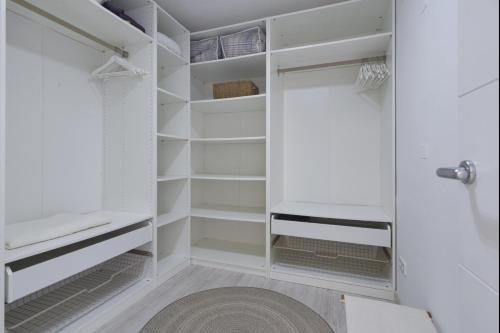 - un dressing avec des étagères blanches et un tapis dans l'établissement Ses Baules - Grupo Berna, à Colonia Sant Jordi