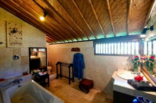 a large bathroom with a tub and a sink at Jivaa 1 BR Superior Garden View ZN239 in Ubud