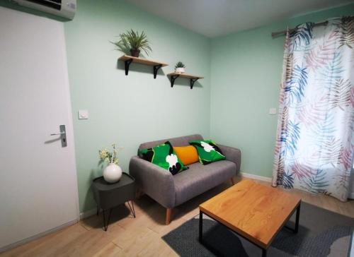un salon avec un canapé et une table dans l'établissement Bel appartement T2 meublé proche de Toulouse, à Mondonville