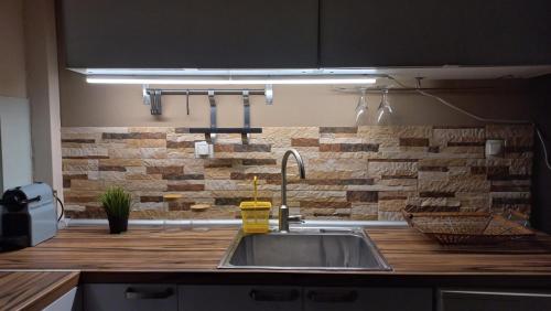 a kitchen with a sink and a brick wall at uRban Loft Living in Kardítsa