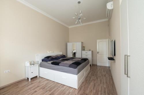 a white bedroom with a bed and a television at D17 Apartment in Budapest