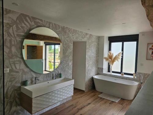 une salle de bain avec une grande baignoire et un grand miroir dans l'établissement Maison 9 personnes pour les événements sportifs, à Laigné-en-Belin