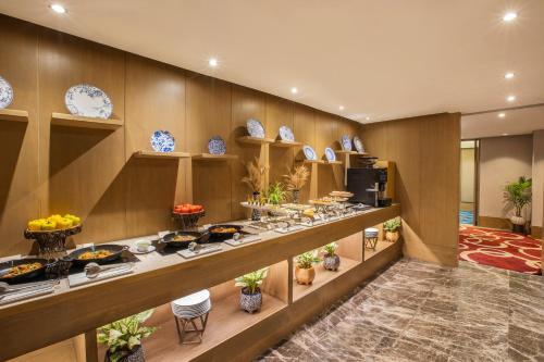 a buffet line in a hotel room with dishes on it at The Leela Ambience Convention Hotel Delhi in New Delhi
