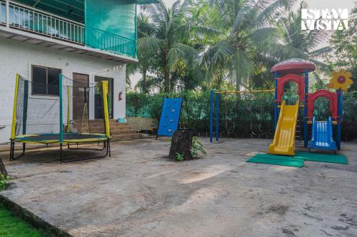 a playground in front of a house at Sundream Palms by VEO - Part of StayVista with Pool, Lawn, BBQ in Alibag