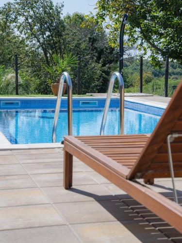 a wooden bench sitting next to a swimming pool at Relax&Wine house Klara in Ruškovac